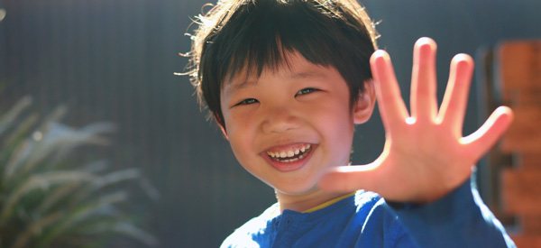 Happy boy waving to the camera